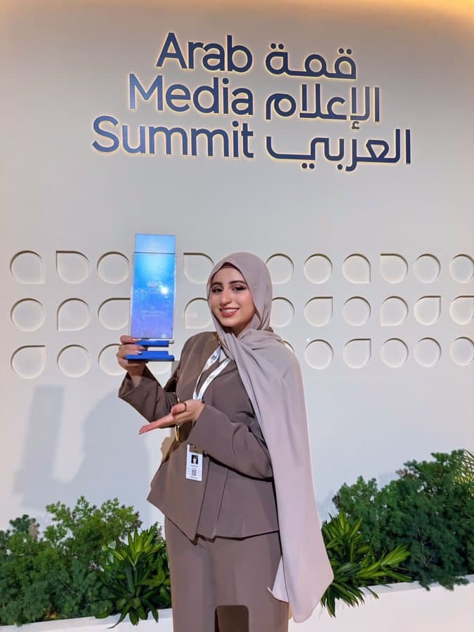 Rahaf holding the Arab Youth Media Award trophy at the Arab Media Summit